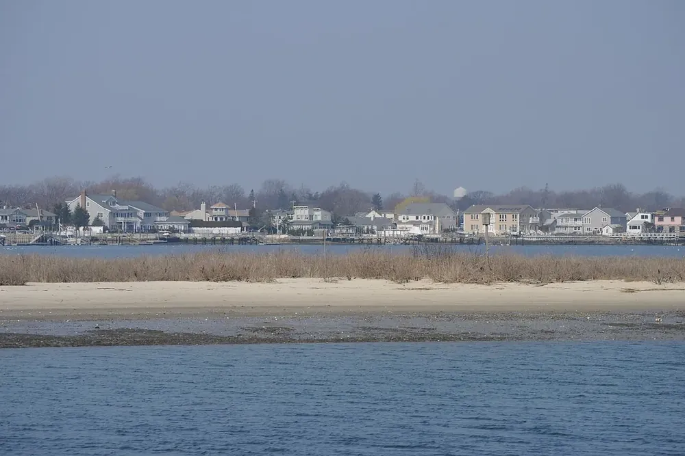 View across Baldwin Bay toward waterfront homes from the shore park in Freeport, New York