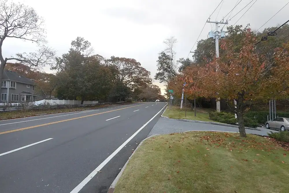 Tree-lined road with autumn foliage and a grassy shoulder in Ronkonkoma, New York