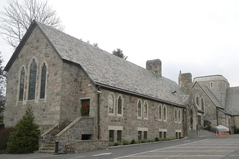 Gray stone church with tall arched windows in Scarsdale, New York
