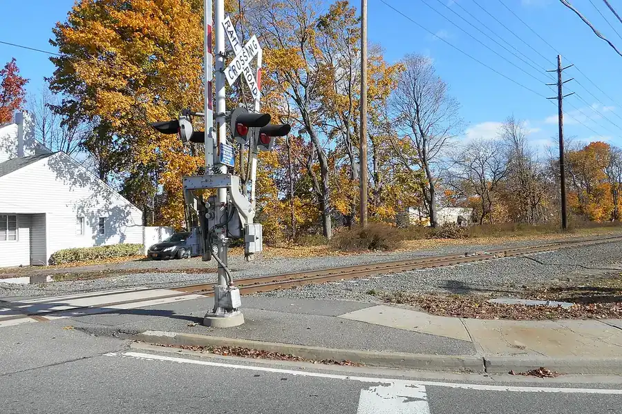 Railroad crossing beside autumn trees on a quiet road in South Farmingdale, New York